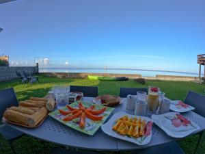 a table with food on it with the ocean in the background at Hava'e Lodge TEAHUPOO in Teahupoo