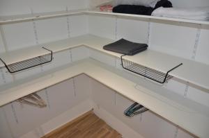 ein Kleiderschrank mit weißen Schränken und weißen Regalen in der Unterkunft Maison de village palau del vidre in Palau-del-Vidre