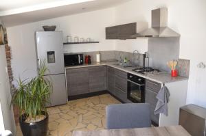 eine Küche mit einem Kühlschrank und einem Tisch darin in der Unterkunft Maison de village palau del vidre in Palau-del-Vidre