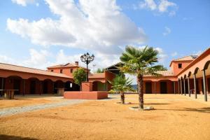 a courtyard with a palm tree and a building at Finca para eventos y complejo rural Mi Cobijo in Fuentelviejo