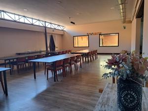 a dining room with tables and chairs and flowers at Finca para eventos y complejo rural Mi Cobijo in Fuentelviejo
