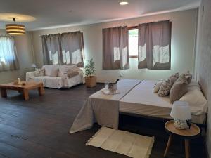 a bedroom with a large bed and a living room at Finca para eventos y complejo rural Mi Cobijo in Fuentelviejo +40 photos