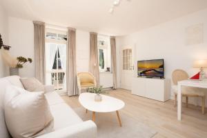 ein weißes Wohnzimmer mit einem weißen Sofa und einem Tisch in der Unterkunft Villa Eden Binz Typ 3 / Apartment 12 in Binz