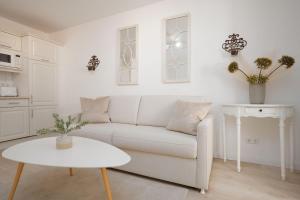 ein weißes Wohnzimmer mit einem weißen Sofa und einem Tisch in der Unterkunft Villa Eden Binz Typ 3 / Apartment 12 in Binz