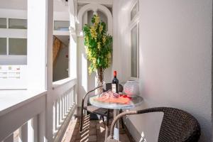 einen kleinen Tisch auf einem Balkon mit einer Flasche Wein in der Unterkunft Villa Eden Binz Typ 3 / Apartment 12 in Binz + 13 Fotos