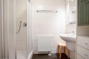 ein weißes Badezimmer mit Waschbecken und Dusche in der Unterkunft Villa Eden Binz Typ 3 / Apartment 12 in Binz