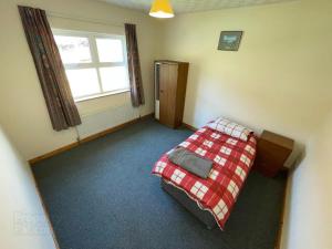 a bedroom with a bed in a room with a window at Causeway holiday home in Ballycastle