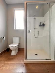 a bathroom with a shower and a toilet at Stylish Freemans Bay Stay in Auckland +22 photos