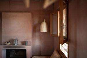 a living room with a fireplace and a window at eumelia organic agrotourism farm in Goúvai +75 photos