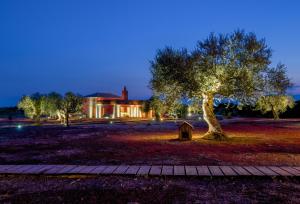a tree in front of a house with a building at eumelia organic agrotourism farm in Goúvai