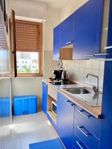 a kitchen with blue cabinets and a sink at Blue apartment, Alghero, near beaches in Alghero