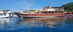 a large boat is docked in the water at Semi Phinisi boat Labuan Bajo Komodo Tour in Pulau Kukusan