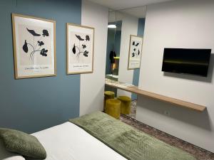 a bedroom with a bed and a tv on a wall at Grey Residence in Drobeta-Turnu Severin