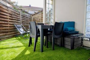 a patio with a table and chairs on grass at Residence du Centre Joli studio rénové avec coin nuit terrasse et parking privé in Capbreton