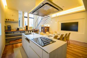 a kitchen and dining room with a table and a tv at Yoichi Nap in Yoichi