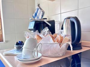a counter with a basket of pastries and a toaster at Blue apartment, Alghero, near beaches in Alghero