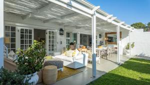 una pérgola blanca en la parte superior de una casa en 15B Rothersand Beach House, en Plettenberg Bay