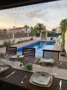 stół z talerzami i kieliszkami oraz basen w obiekcie Riumar Nature 38 , piscina , aire acondicionado , barbacoa y pàrquing Privado w mieście Riumar