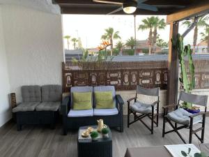 patio z 2 krzesłami, kanapą i stołem w obiekcie Riumar Nature 38 , piscina , aire acondicionado , barbacoa y pàrquing Privado w mieście Riumar