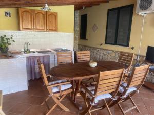 a wooden table and chairs in a kitchen at Villetta SCHIRÒ - BAGNASCO in Campofelice di Roccella