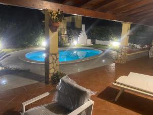 a swimming pool in a backyard at night at Villetta SCHIRÒ - BAGNASCO in Campofelice di Roccella