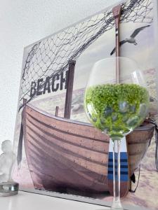 a glass of wine sitting next to a picture of a boat at Blue apartment, Alghero, near beaches in Alghero +1 photo