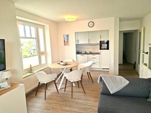 a kitchen and living room with a table and chairs at de Bark in Dorum-Neufeld