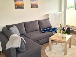 a living room with a gray couch and a table at de Bark in Dorum-Neufeld +17 photos