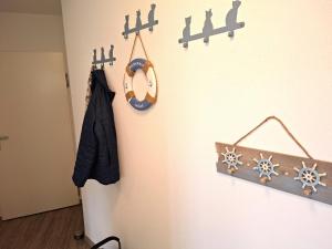a room with a wall with a clock and a coat at de Bark in Dorum-Neufeld
