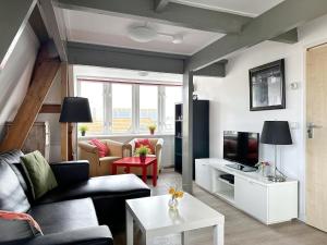 a living room with a couch and a tv at Huis van Egmond aan Zee in Egmond aan Zee