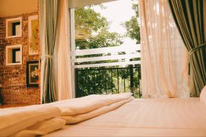 a bedroom with a bed and a large window at Căn Bighomie in Sóc Sơn
