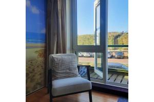 a chair sitting in front of a window at Torenlicht in Egmond aan Zee