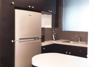 a small kitchen with a refrigerator and a sink at Casa Corp Boutique Suites in Condesa in Mexico City