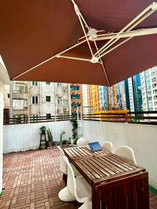 um pátio com uma mesa, cadeiras e um guarda-sol em Standard studio Room with RoofTop near LKF central em Hong Kong mais 5 fotografias