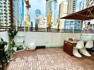 uma varanda com uma mesa, cadeiras e edifícios em Standard studio Room with RoofTop near LKF central em Hong Kong