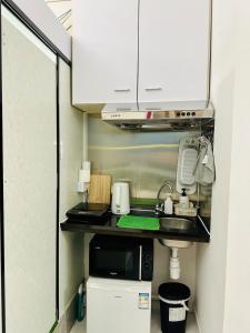 uma pequena cozinha com pia e micro-ondas em Standard studio Room with RoofTop near LKF central em Hong Kong