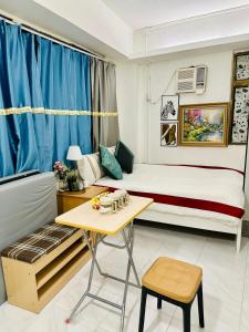 um pequeno quarto com uma cama e uma mesa em Standard studio Room with RoofTop near LKF central em Hong Kong