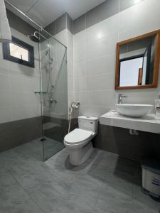 a bathroom with a toilet and a sink and a shower at Hotel Phạm Gia Phan Thiết in Phan Thiet +95 photos