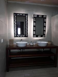 a bathroom with two sinks and a mirror at La Creole APT 09 in Toamasina +1 photo
