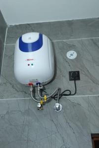 a white and blue machine on a marble floor at Evara Homestay in Dwārīkhāl