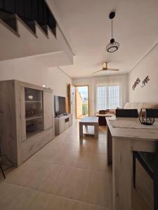 a large living room with a couch and a tv at Villa Terreros 67 in San Juan de los Terreros +32 photos
