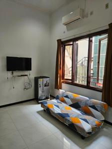 ein Schlafzimmer mit einem Bett und einem Fenster in der Unterkunft Grand Valora 1 in Semarang