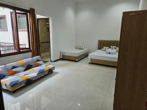 ein Zimmer mit zwei Betten und einem Spiegel in der Unterkunft Grand Valora 1 in Semarang