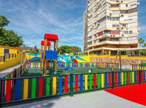 Un parque infantil con una zona de juegos colorida en una ciudad. en Estudio vistas campo golf y piscina, en Torremolinos