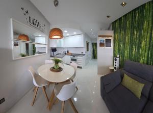 Una cocina y una sala de estar con una mesa y un sofá. en Estudio vistas campo golf y piscina, en Torremolinos