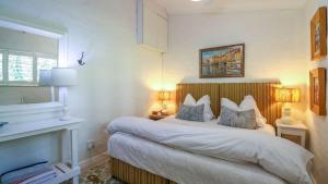 Un dormitorio con una cama con dos almohadas encima. en 15B Rothersand Beach House, en Plettenberg Bay