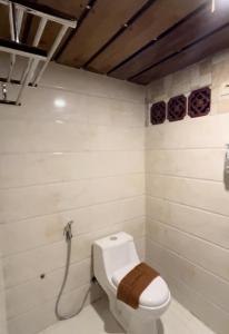 a bathroom with a white toilet in a room at Serenity Villa Guci in Tuwel