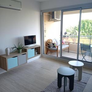 a living room with a tv and a balcony at Appartement cosy Sanary centre-Climatisé-Parking privé in Sanary-sur-Mer