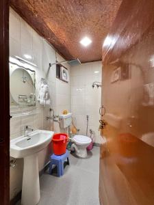 a bathroom with a sink and a toilet at Tourist pure veg Hotel And Restaurant in Lansdowne +11 photos