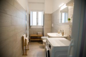 a white bathroom with a sink and a toilet at Acqua Holiday House in Taranto